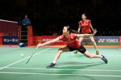 【女子ダブルス・準決勝】第２ゲーム、シャトルをひろう永原和可那（手前）。後方は松本麻佑（金野和彦撮影）