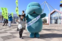 ネクスコのキャラクター「マナーティ」とポーズをとる来場者