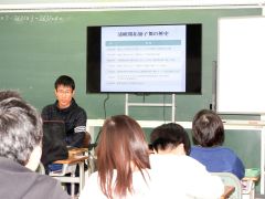 会員（左から２人目）から「開拓獅子舞い」の歴史を学ぶ児童たち
