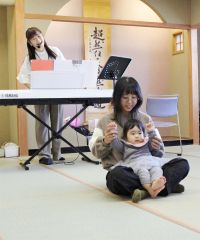 ピアノに合わせて名前を呼び、手を上げる親子