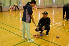 新里プロ(右)にスイングのアドバイスをもらう児童(左)