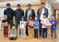 どんぐり保育園の園児にヨーグルトを手渡す青年部員たち