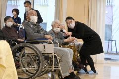 社会福祉施設の利用者にマイクを向けて一緒に歌う中村仁美さん(右)