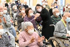 社会福祉施設の利用者らに自慢の歌声を披露する中村仁美さん(中央)