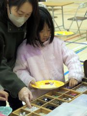 アクセサリーのパーツを相談しながら決める親子
