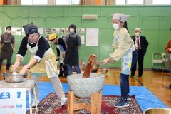 保護者と協力して餅をつく児童たち