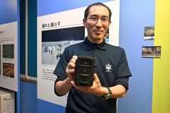 定点撮影するトレイルカメラを手にする金森さん