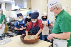 そば粉をこねていく作業を体験する参加者
