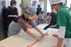 こねたそば粉を延ばしていく参加者