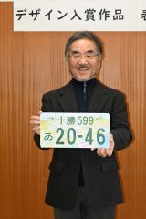 デザイン画を手に笑顔を見せる栗田さん