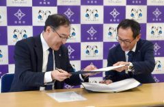 署名した協定書を交換する井上町長と大橋支社長（右から）