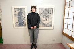 版画作品の前に立つ篠田さん
