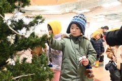 雪だるまやサンタなどのオーナメントを飾る園児ら