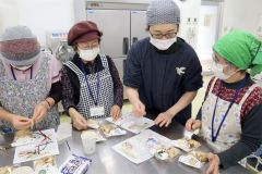 浦木さん(右から2人目)と焼きあがったチョコチャンクスコーンをラッピングする受講者ら