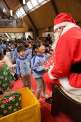 サンタクロースからプレゼントをもらい、笑顔を見せる園児（１５日、助川かおる通信員撮影）
