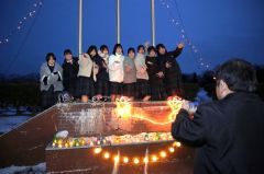 イルミネーションに飾られた校舎前で写真撮影を楽しむ生徒たち（助川かおる通信員撮影）