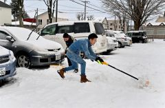 駐車場の雪を除雪する請負業者（１７日午前８時２０分ごろ、市内西１０南１９。金野和彦撮影）