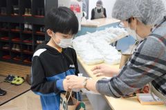 お弁当を手渡しする藤原代表（右）
