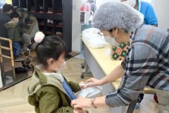 お弁当を手渡しする藤原代表（右）