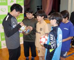 圓道さん(左)にサインをもらう児童
