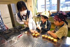 カップケーキに生クリームをトッピングする子どもたち