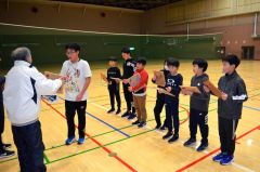 中島さん（左）からサイン入り色紙を受け取る児童
