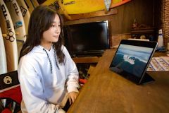 ホーム・ビーチのフンベ海岸をバックに。「自然の中で楽しめるのがサーフィンの魅力」という（撮影・石原秀樹通信員）