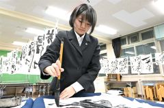 真剣な眼差しで筆を走らせる伊藤さん（須貝拓也撮影）