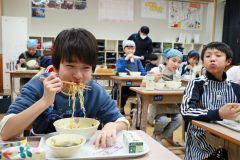 高校生考案の給食メニューを味わう児童