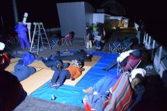 あおむけになってふたご座流星群を観測する来館者たち