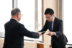 有塚組合長から激励状を受け取る新規就農者（右）