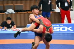 【男子グレコローマンスタイル６７キロ級予備戦】第１ピリオド、相手を持ち上げ技を仕掛ける清水賢亮（青色のシングレット）＝金野和彦撮影