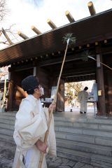 神門をすす払いする神職(28日午前9時半ごろ、帯廣神社で。助川かおる通信員)