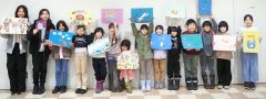 完成した作品とともに記念撮影をする子どもたち