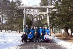 新調した大しめ縄と、野村社長（前列左から２人目）、野村会長（同３人目）、波多野社長（同４人目）ら関係者。前列右は佐々木宮司