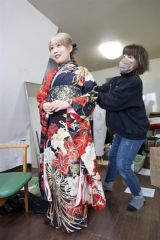 手際よく着付けを行う美容室のスタッフと華やかな振り袖に笑顔を見せる女性（７日午前９時ごろ、ルッコラで。平栗玲香通信員撮影）