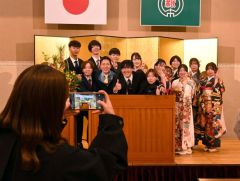 式が終わりリラックスした雰囲気で写真を撮る参加者たち（３日、新得。平田幸嗣撮影）