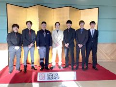 屏風前でスーツ姿で記念撮影に収まる男性たち（３日、陸別。北雅貴撮影）