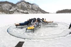 アイスカルーセル（湖の氷を円形に切り出し、メリーゴーラウンドのように回る遊び）でクールダウンする参加者