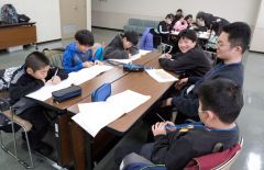 北大生（右）から宿題を教える児童