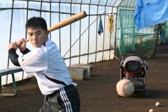 ビニールハウスの室内練習場でティーバッティングに臨む音更高野球部員。奥には室内を温めるためのジェットヒーターが見える