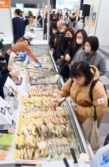 販売員の説明を受けながらチーズや乳製品を買い求める来場者（１２日午前１０時半ごろ、とかちプラザ特設会場で。金野和彦撮影）