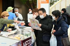 お目当ての乳製品は？　チラシを見ながら店を探す来場者
