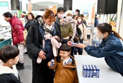 先着１００人に「ウエルカムミルク」として２００ミリリットルのロングライフ牛乳が配られた。１４日も配布する
