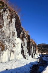 氷結した水の流れが岩肌を覆っているフンベの滝（１３日午前７時５０分ごろ）