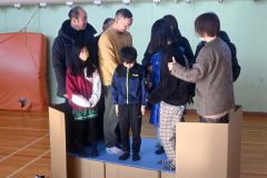 完成したダンボールベッドを試す住民ら