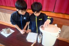 アルファ米にお湯を入れる子どもたち