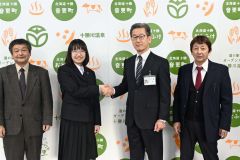 福地教育長（右から２人目）と握手を交わす市山さん（同３人目）と引率の橋本専務理事（右）と名内会長（左）