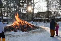 どんど焼きの炎の前で祈願する参拝者（１５日午前８時半ごろ、帯廣神社で）