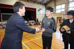 大石校長からグラブを受け取る幕別札内北小の児童会（１５日午前９時５０分ごろ、助川かおる通信員撮影）